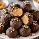 Schritt-für-Schritt-Anleitung für Erdnussbutterbällchen (Rosskastanien) mit cremiger Erdnussbutterfüllung, geschmolzener Schokolade und gehackten Erdnüssen als Dekoration.